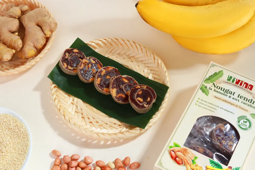 Coffret VIVINA et assiette de nougats sur une feuille de bananier